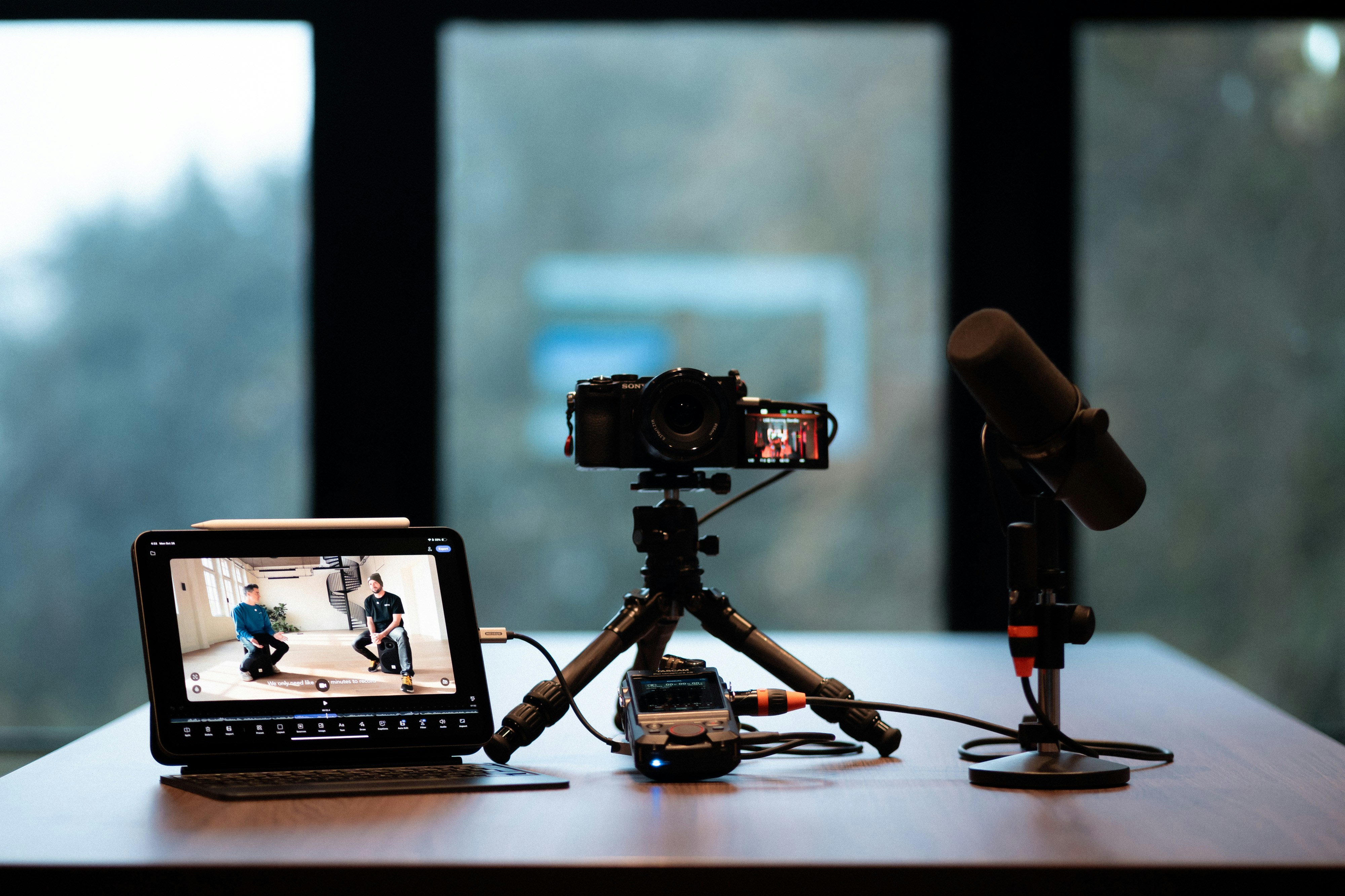 Podcast and video recording setup with camera, microphone, and tablet